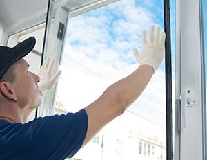 man replacing window pane